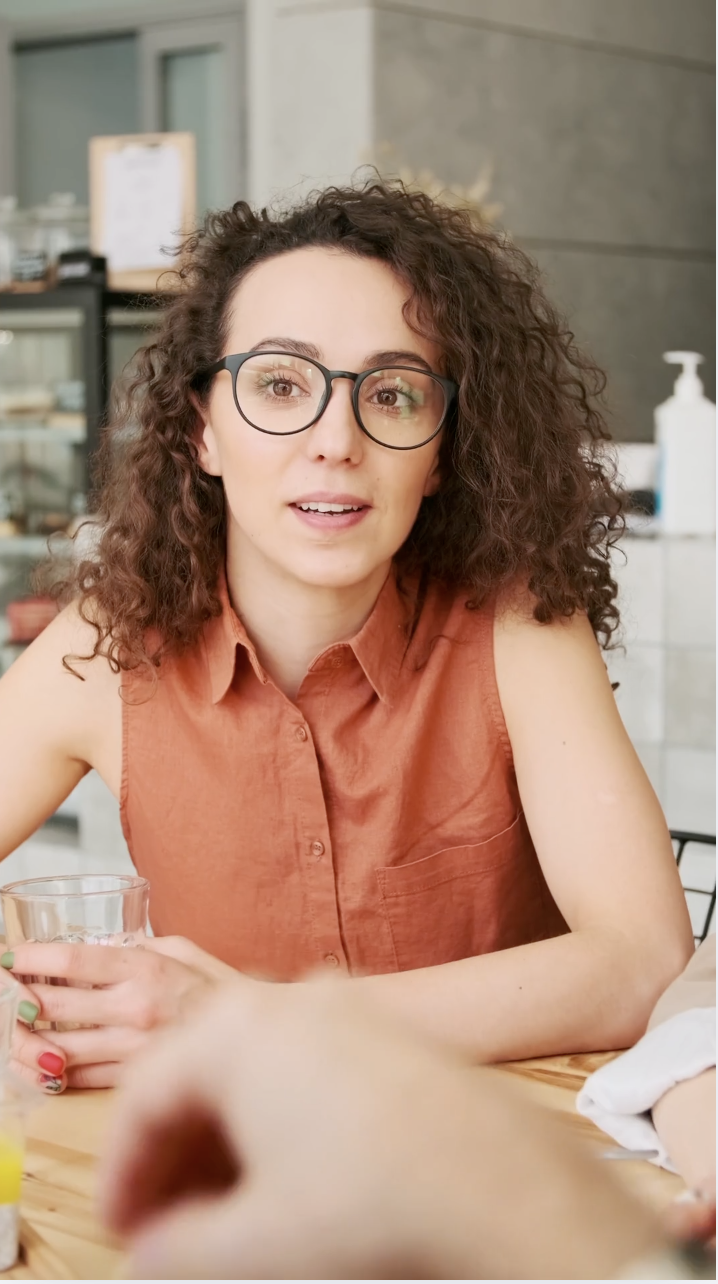Employee in conversation, talking at a table in an informal setting.