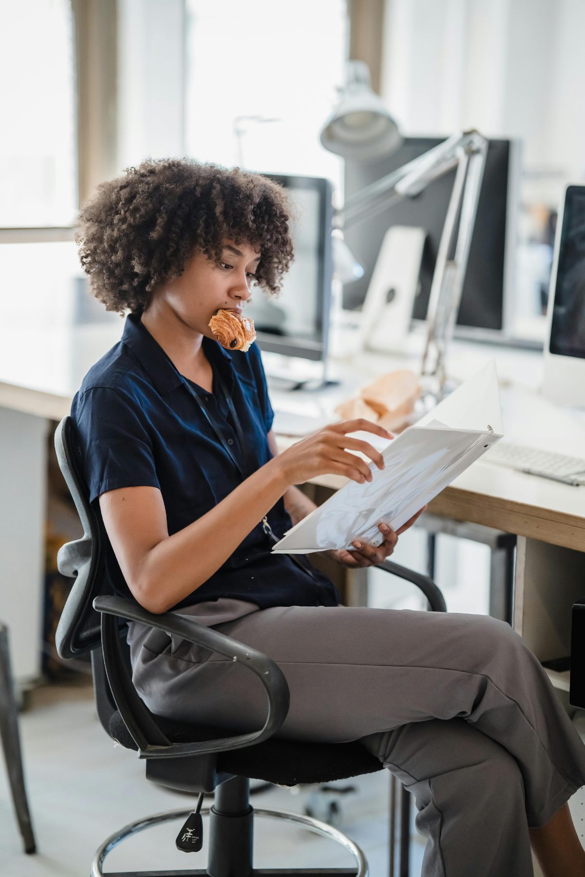 An office worker looks at a document during an informal work break.