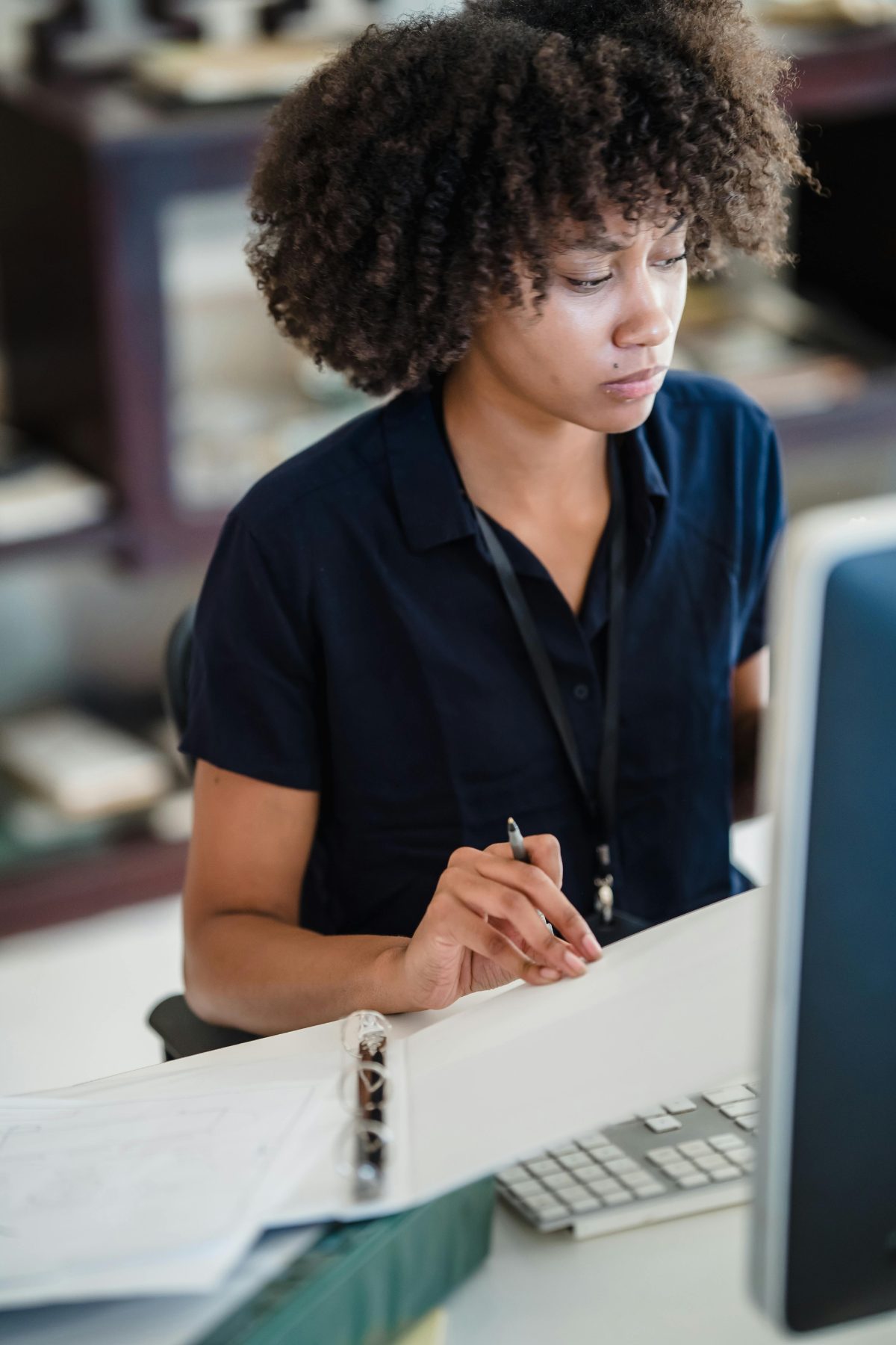 Medewerker maakt aantekeningen achter een computerscherm op kantoor