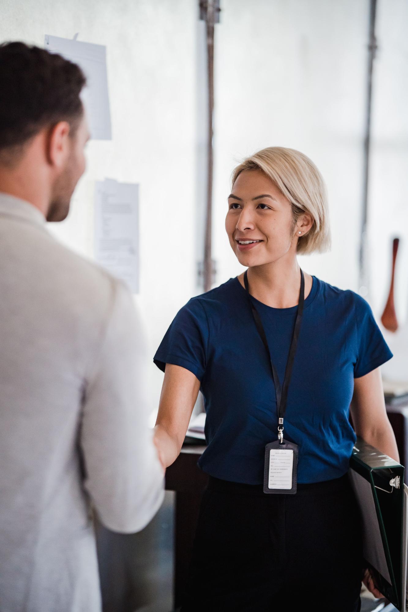 Colleague wearing a name badge says goodbye to an employee.