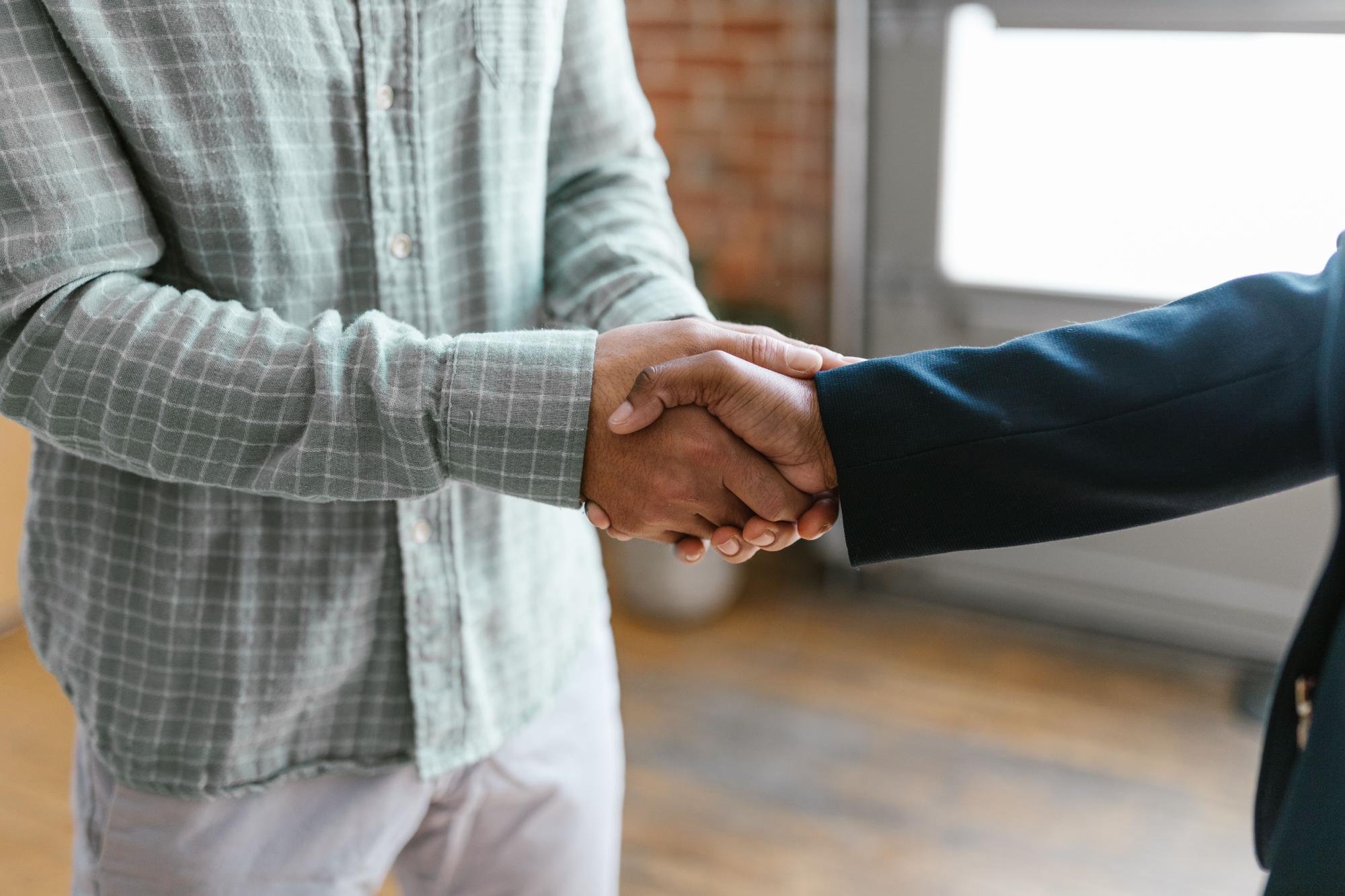 Close-up van een handdruk tussen twee collega's op kantoor